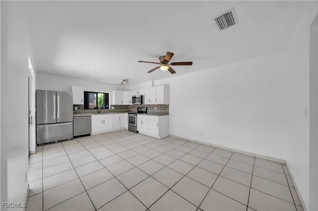a kitchen with white cabinets a sink appliances and cabinets