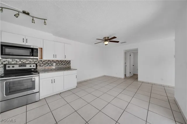 a kitchen with granite countertop white cabinets stainless steel appliances and a sink