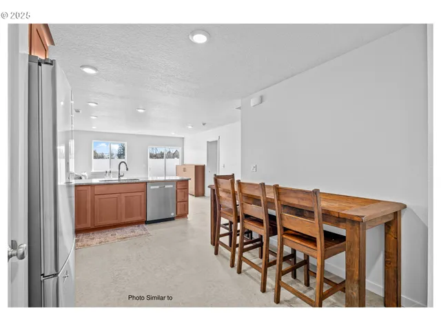 a dining room with furniture and kitchen view