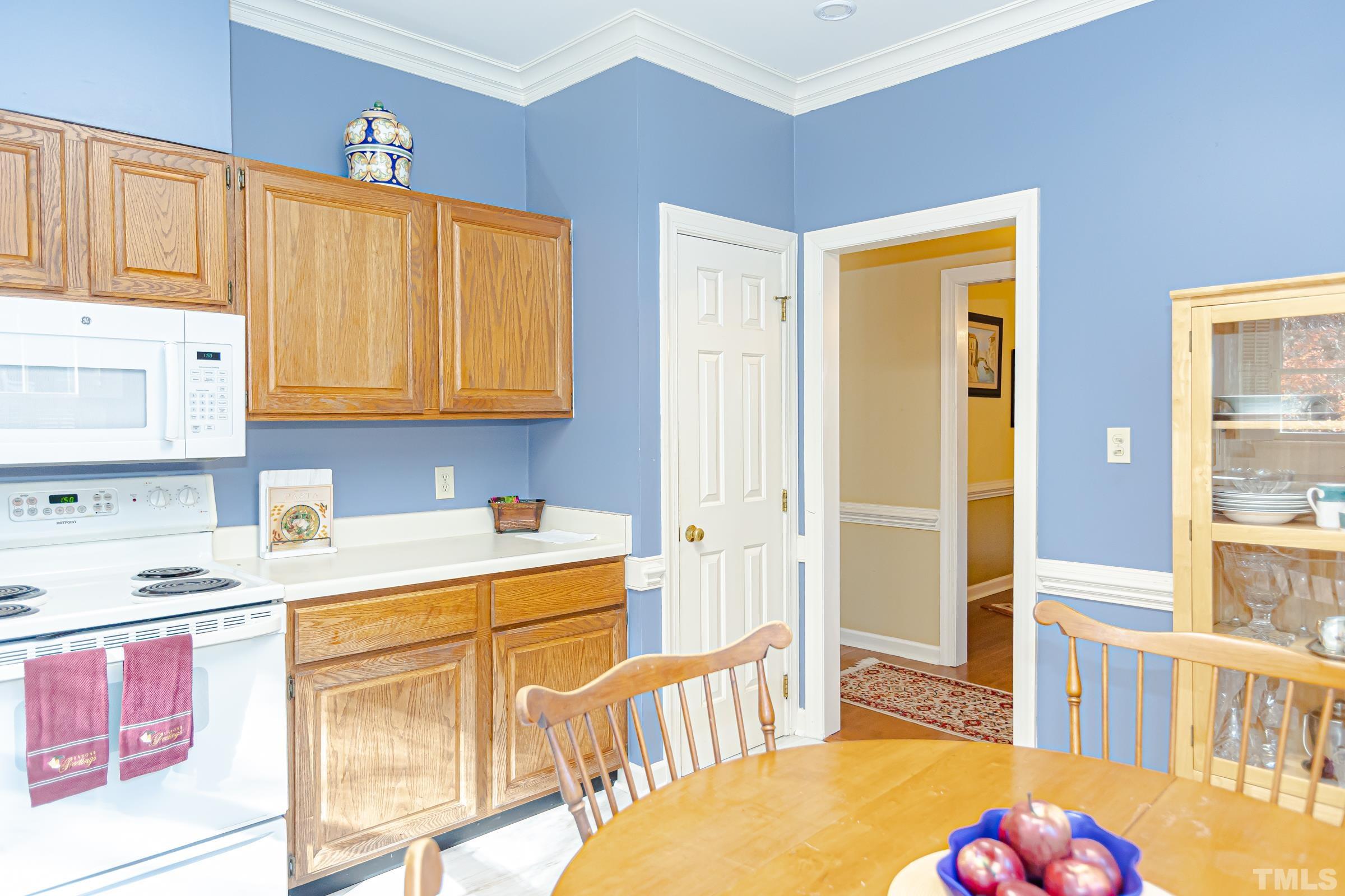 410 Weathergreen Drive Raleigh, NC 27615 - Photo 11 of 44 a kitchen that has a lot of cabinets a sink and a wooden floor
