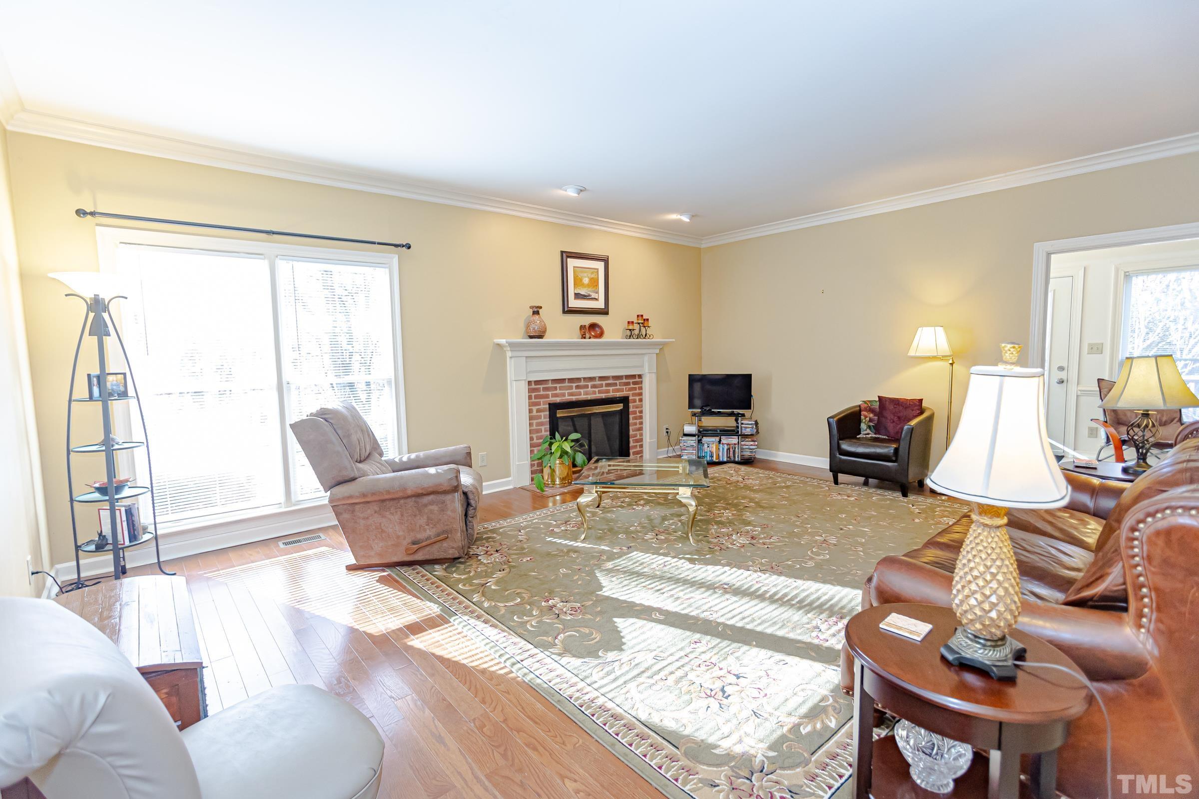 410 Weathergreen Drive Raleigh, NC 27615 - Photo 13 of 44 a living room with furniture a fireplace and a large window