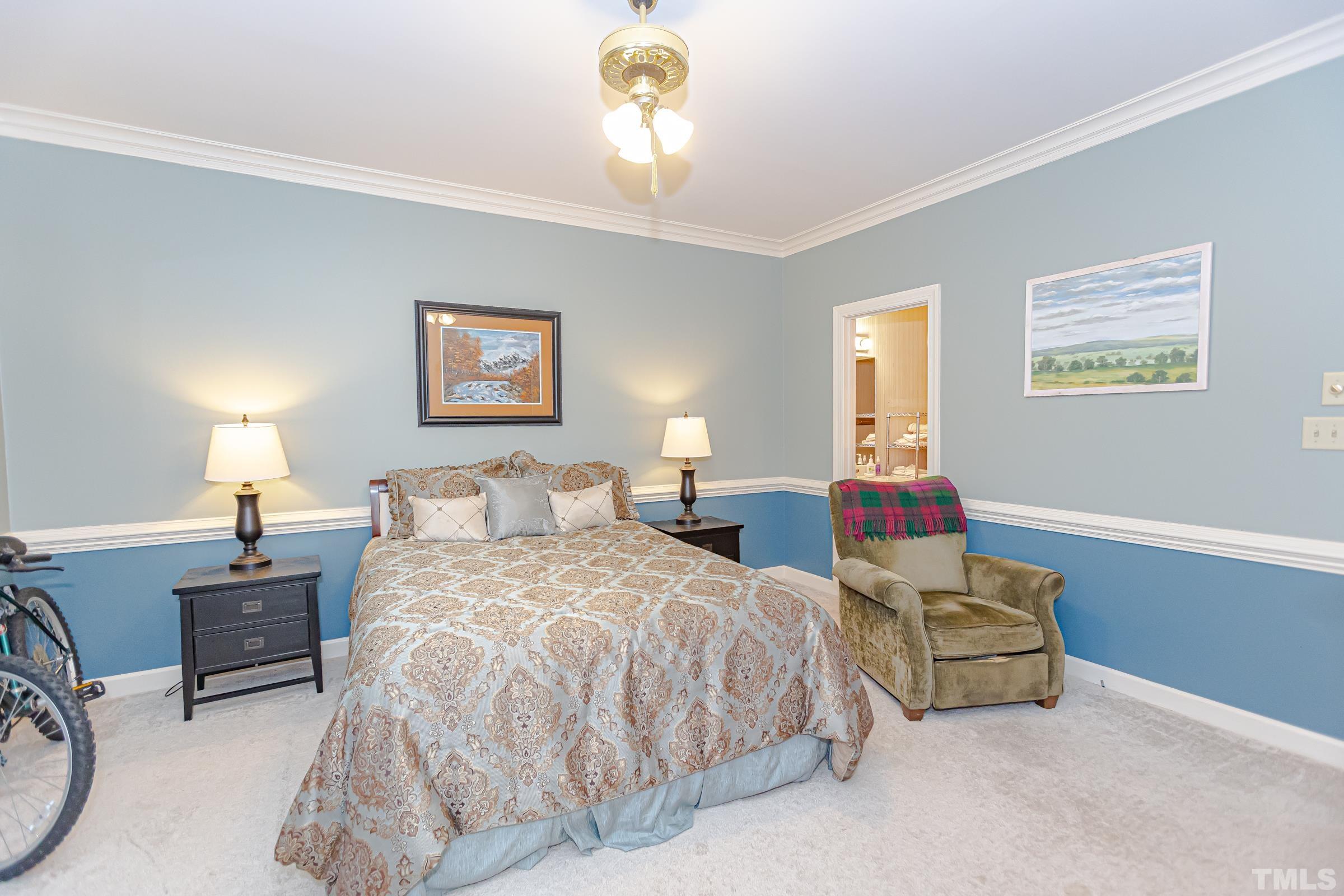 410 Weathergreen Drive Raleigh, NC 27615 - Photo 20 of 44 a spacious bedroom with a bed and a chandelier