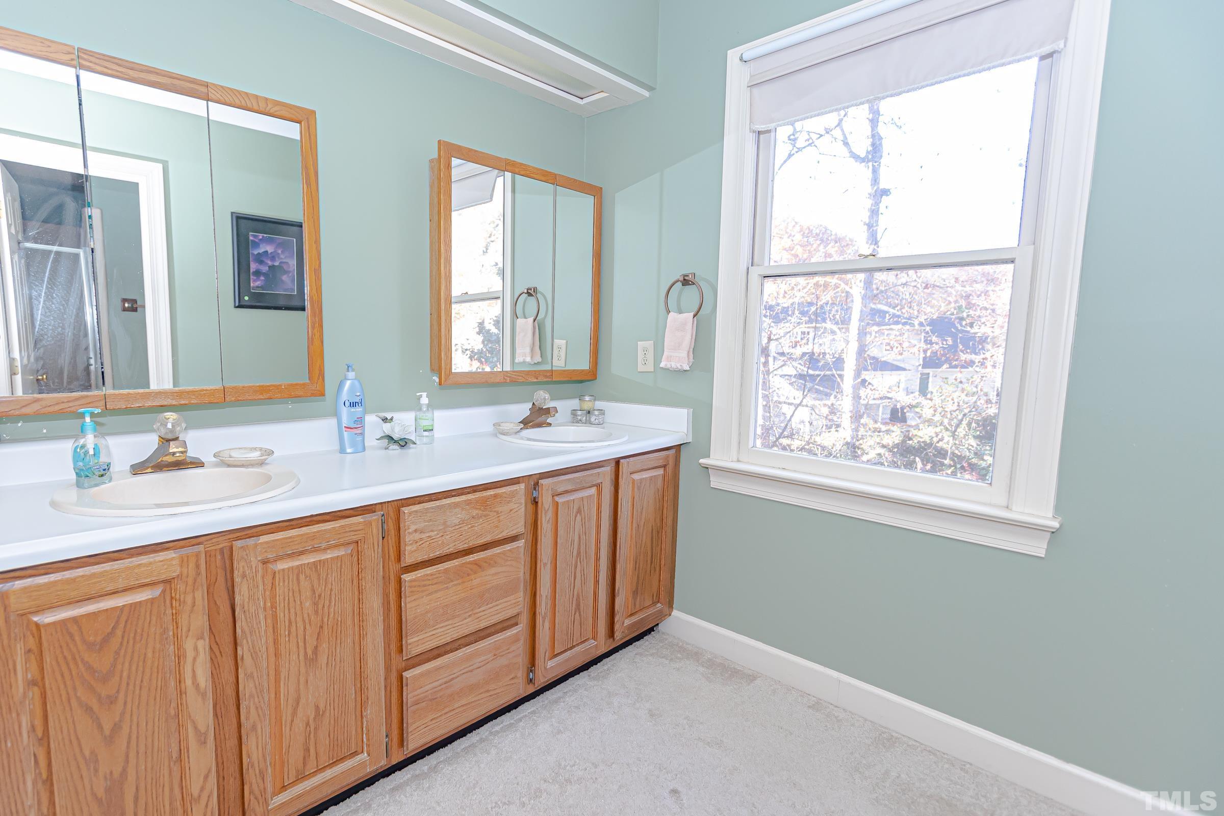 410 Weathergreen Drive Raleigh, NC 27615 - Photo 27 of 44 a bathroom with 2 sink and a mirror
