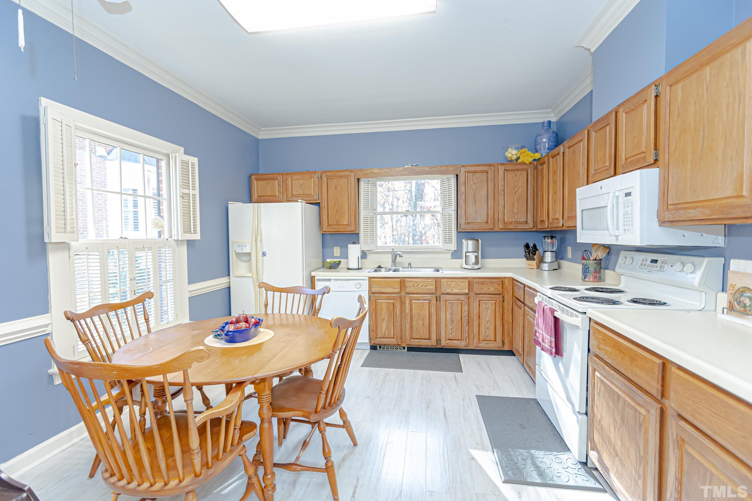 410 Weathergreen Drive Raleigh, NC 27615 - Photo 7 of 44 a kitchen with stainless steel appliances granite countertop a stove a sink a refrigerator a dining table and chairs