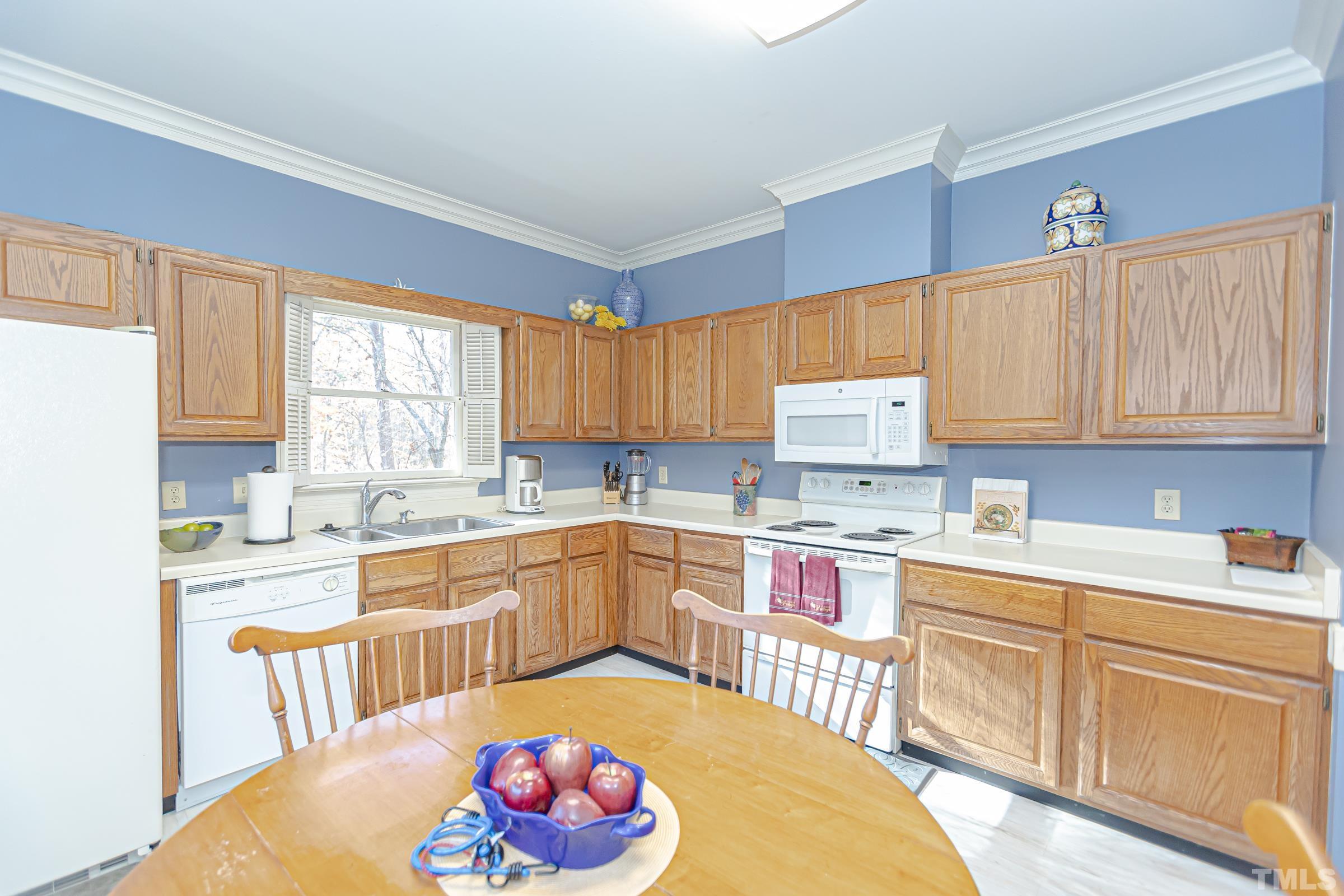 410 Weathergreen Drive Raleigh, NC 27615 - Photo 8 of 44 a kitchen with a stove a sink dishwasher and white cabinets with wooden floor