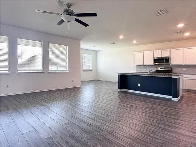a kitchen with sink a microwave and cabinets