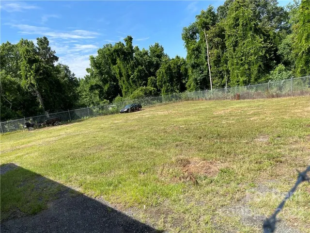a view of a yard with a wooden fence