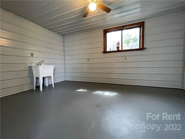 a view of a room with a chair and a ceiling fan