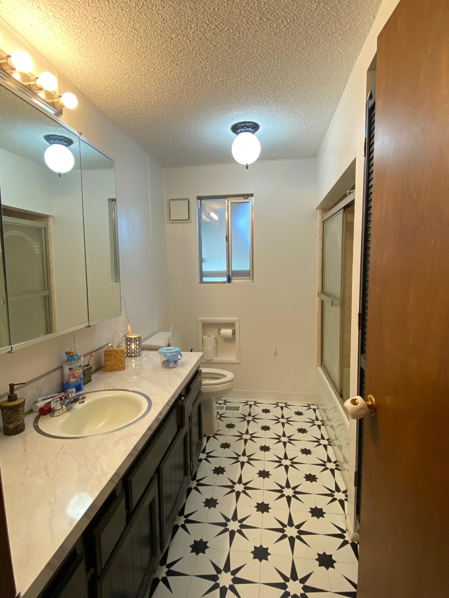 6735 South Prairie Road Tillamook, OR 97141 - Photo 12 of 23 a bathroom with a sink a toilet a mirror and shower