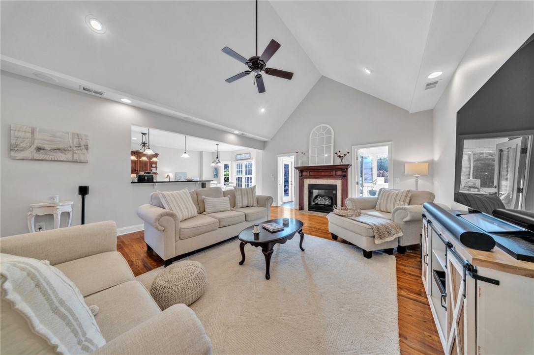 102 Country Walk Lane Clemson, SC 29631 - Photo 3 of 39 A spacious living area featuring vaulted ceilings, rich hardwood floors, and a welcoming fireplace.