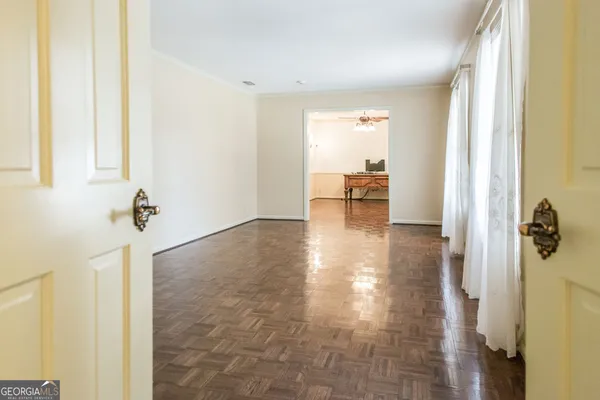 a view of an empty room with wooden floor