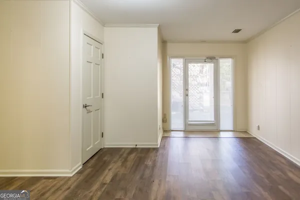 a view of a hallway with wooden floor and windows