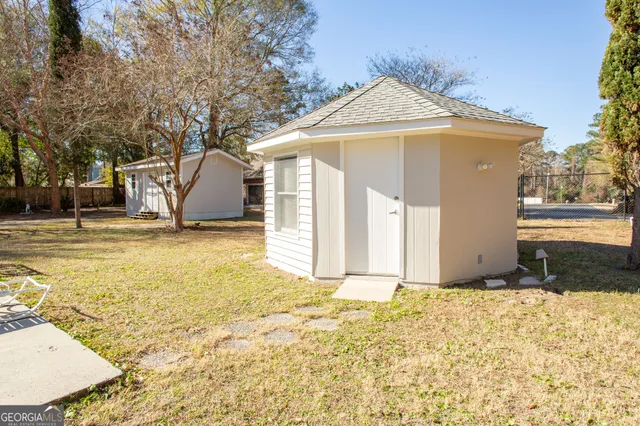 a front view of a house with a yard and trees