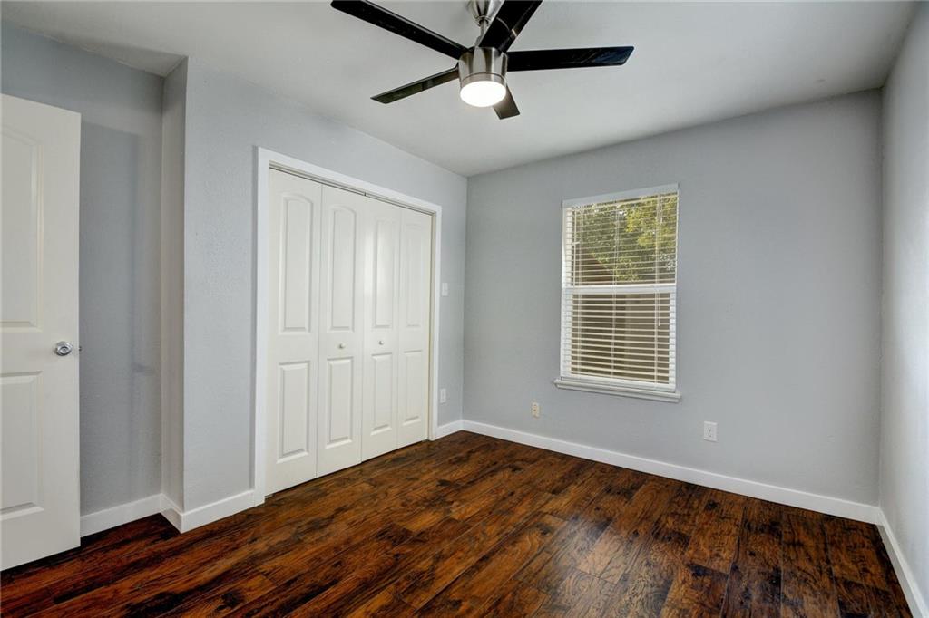 1120 Estes Avenue, Unit B Austin, TX 78721 - Photo 11 of 26 Unfurnished bedroom with dark wood-type flooring, a closet, and a ceiling fan