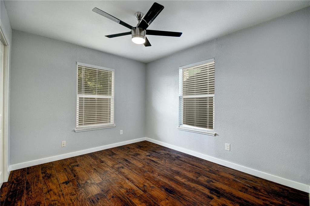 1120 Estes Avenue, Unit B Austin, TX 78721 - Photo 12 of 26 Unfurnished room featuring dark wood-type flooring and a ceiling fan
