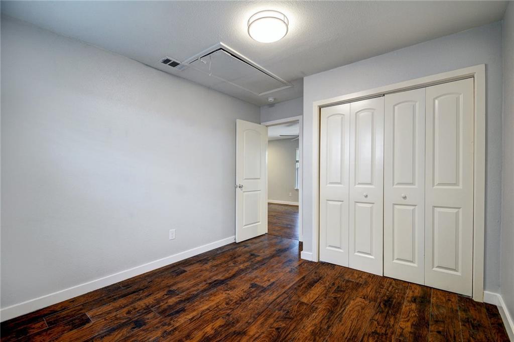 1120 Estes Avenue, Unit B Austin, TX 78721 - Photo 13 of 26 Unfurnished bedroom with attic access, dark wood-style flooring, and a closet