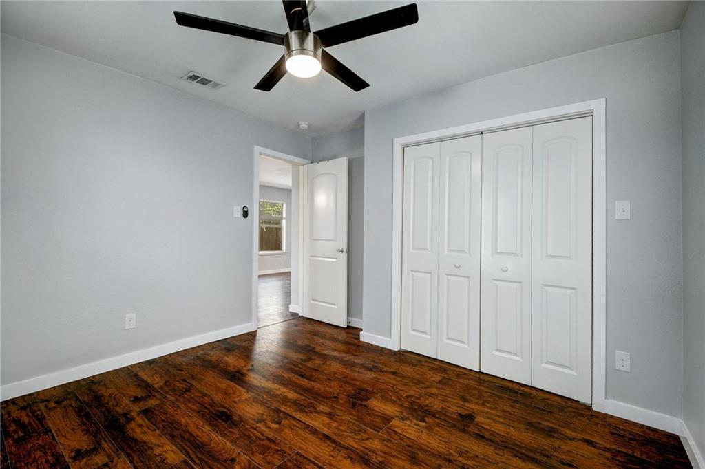 1120 Estes Avenue, Unit B Austin, TX 78721 - Photo 10 of 26 Unfurnished bedroom featuring dark wood-type flooring, a closet, and a ceiling fan