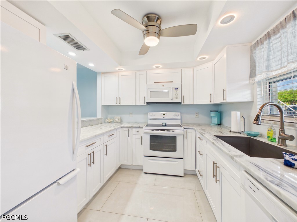 300 Valley Stream Drive, Unit 3D Naples, FL 34113 - Photo 10 of 21 a kitchen with granite countertop white cabinets and white appliances