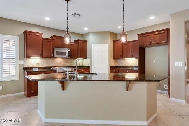 a kitchen with stainless steel appliances granite countertop a sink a stove and refrigerator