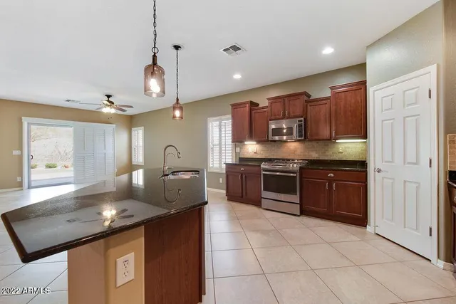 a kitchen with stainless steel appliances granite countertop a sink a stove and a refrigerator