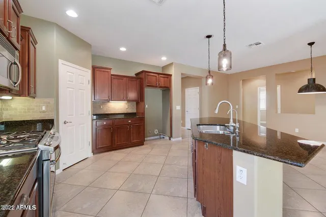 a kitchen with stainless steel appliances granite countertop a sink a stove and a refrigerator