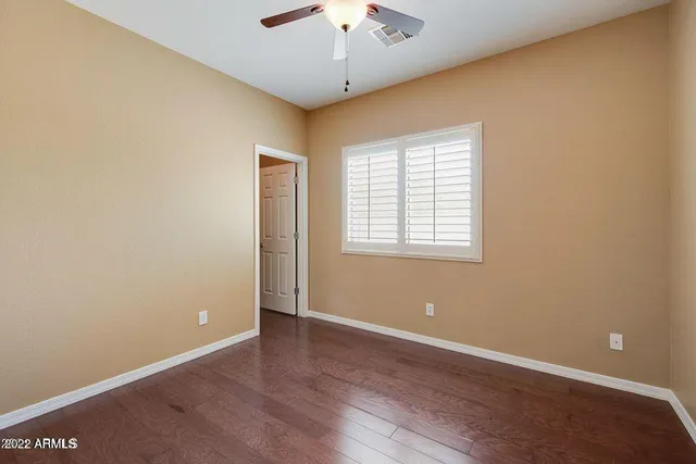 an empty room with a window and a ceiling fan