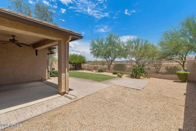 a view of a house with backyard and trees