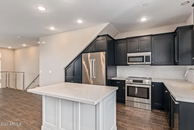 a kitchen with stainless steel appliances kitchen island a cabinets and wooden floor