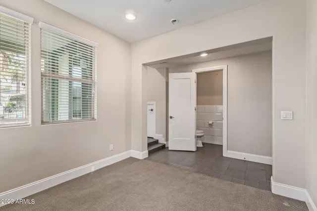 an empty room with a window and a ceiling fan