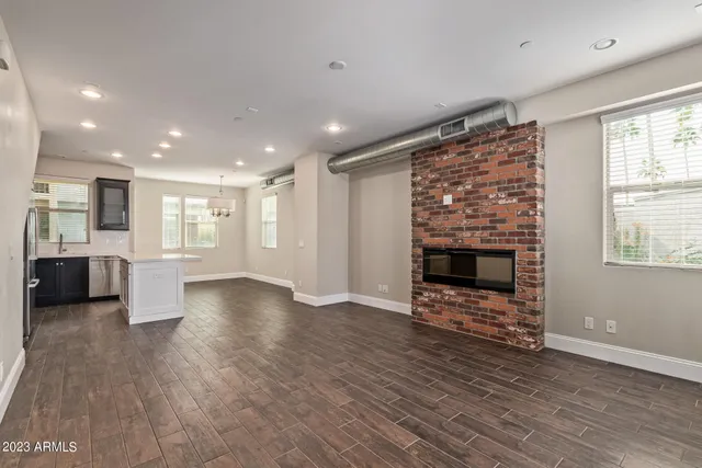 a view of a big room with wooden floor and a fireplace