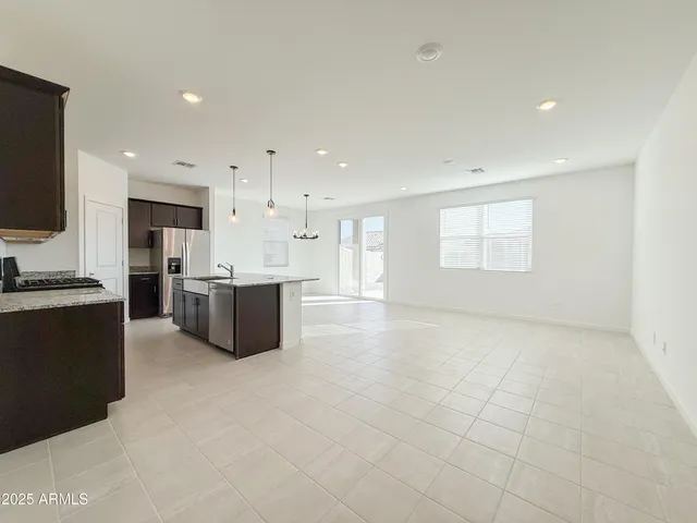 a large white kitchen with a stove a sink dishwasher and a refrigerator with wooden floor