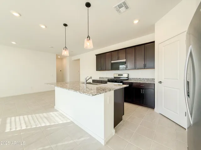 a kitchen with kitchen island a sink stainless steel appliances and cabinets