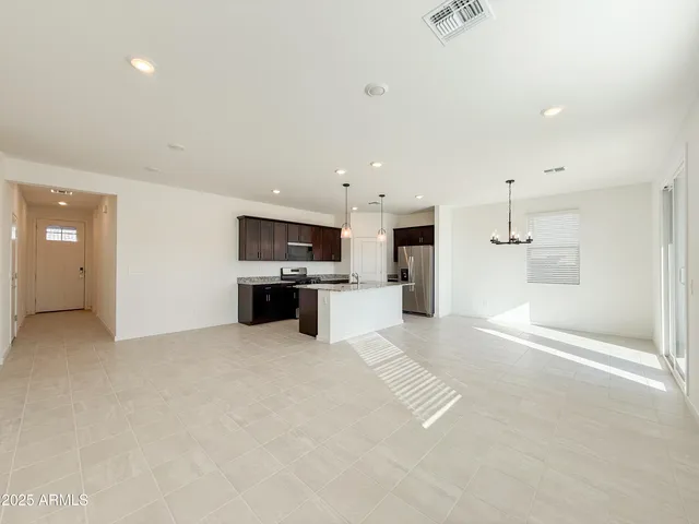 a view of kitchen with kitchen island a sink stainless steel appliances and cabinets