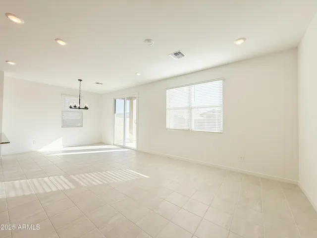 an empty room with windows and cabinet