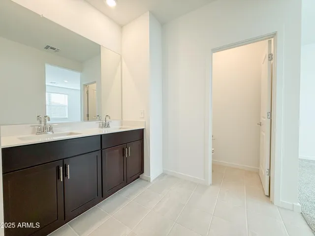 a bathroom with a double vanity sink a mirror and a