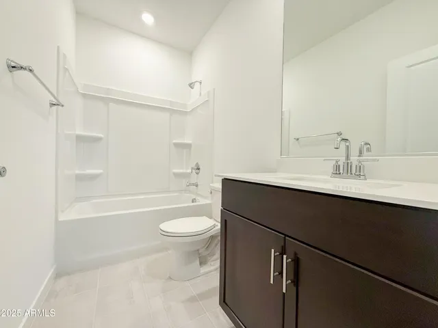 a bathroom with a bathtub sink mirror vanity and toilet