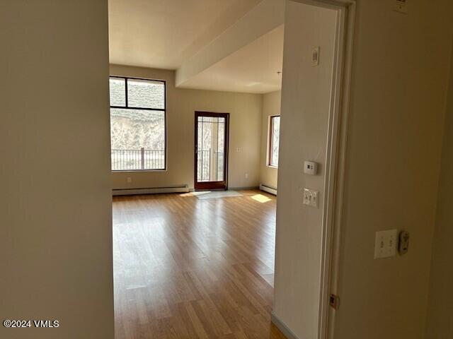 705 Nogal Road, Unit D6 Eagle, CO 81631 - Photo 11 of 15 an empty room with wooden floor and windows with curtains