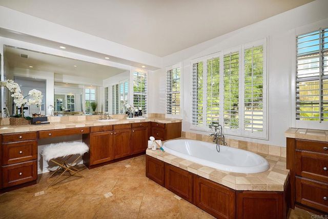 a bedroom with a bed chandelier and a window