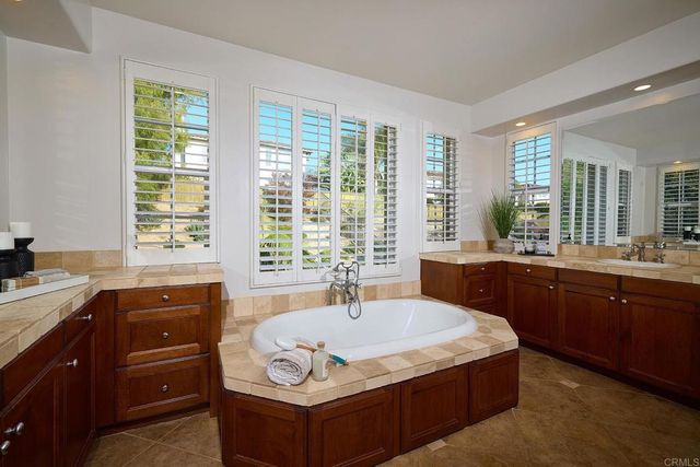 a bathroom with a granite countertop sink a mirror and a shower