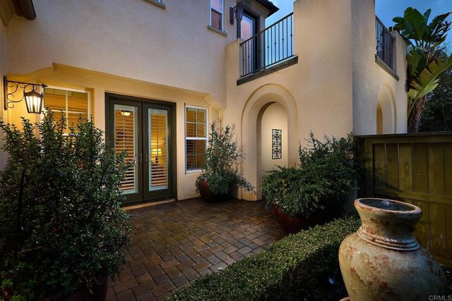 a view of a house with large windows and plants