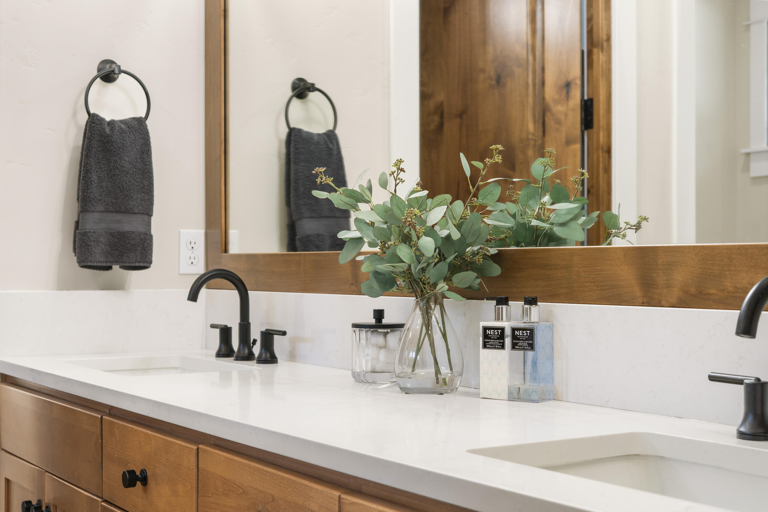 56155 Sable Rock Loop, Unit 277 Bend, OR 97707 - Photo 26 of 63 The spa-inspired primary bath showcases dual vanities, custom wood cabinetry, quartzite countertops, and designer lighting.