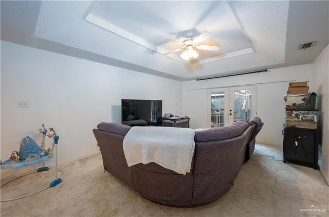 a living room with furniture a flat screen tv and a chandelier
