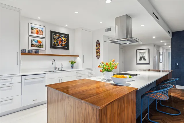 a dining room filled chandelier and kitchen view
