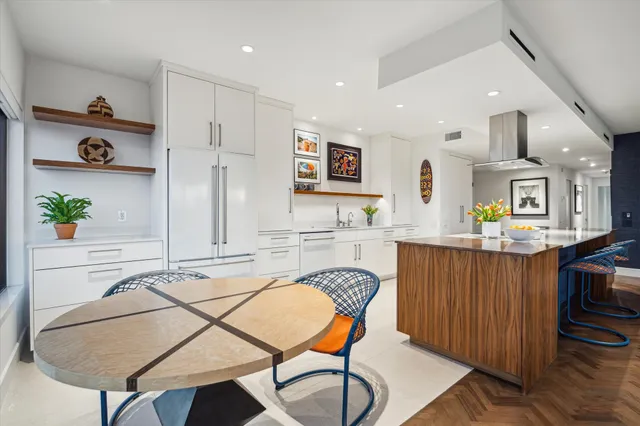 a kitchen with kitchen island stainless steel appliances a dining table and chairs