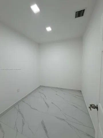 a view of an empty room with white walls