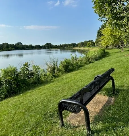 a view of a lake with a yard and a wooden fence