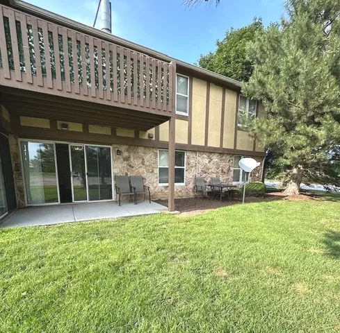 a view of a house with a yard and sitting area