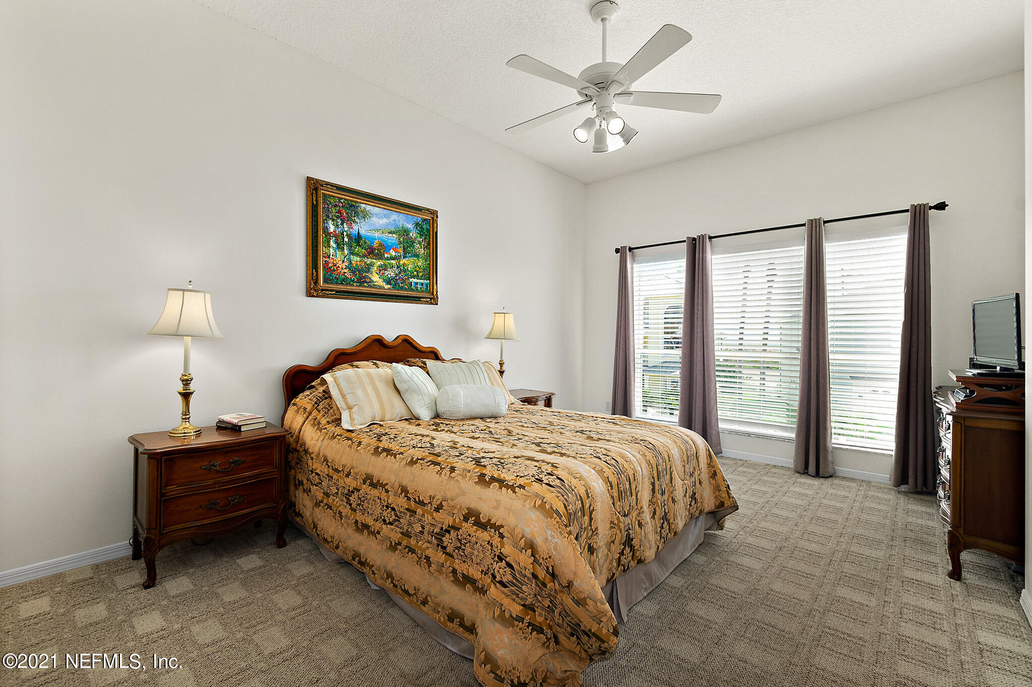 9269 July Lane St. Augustine, FL 32080 - Photo 49 of 105 a spacious bedroom with a bed and a lamp on table
