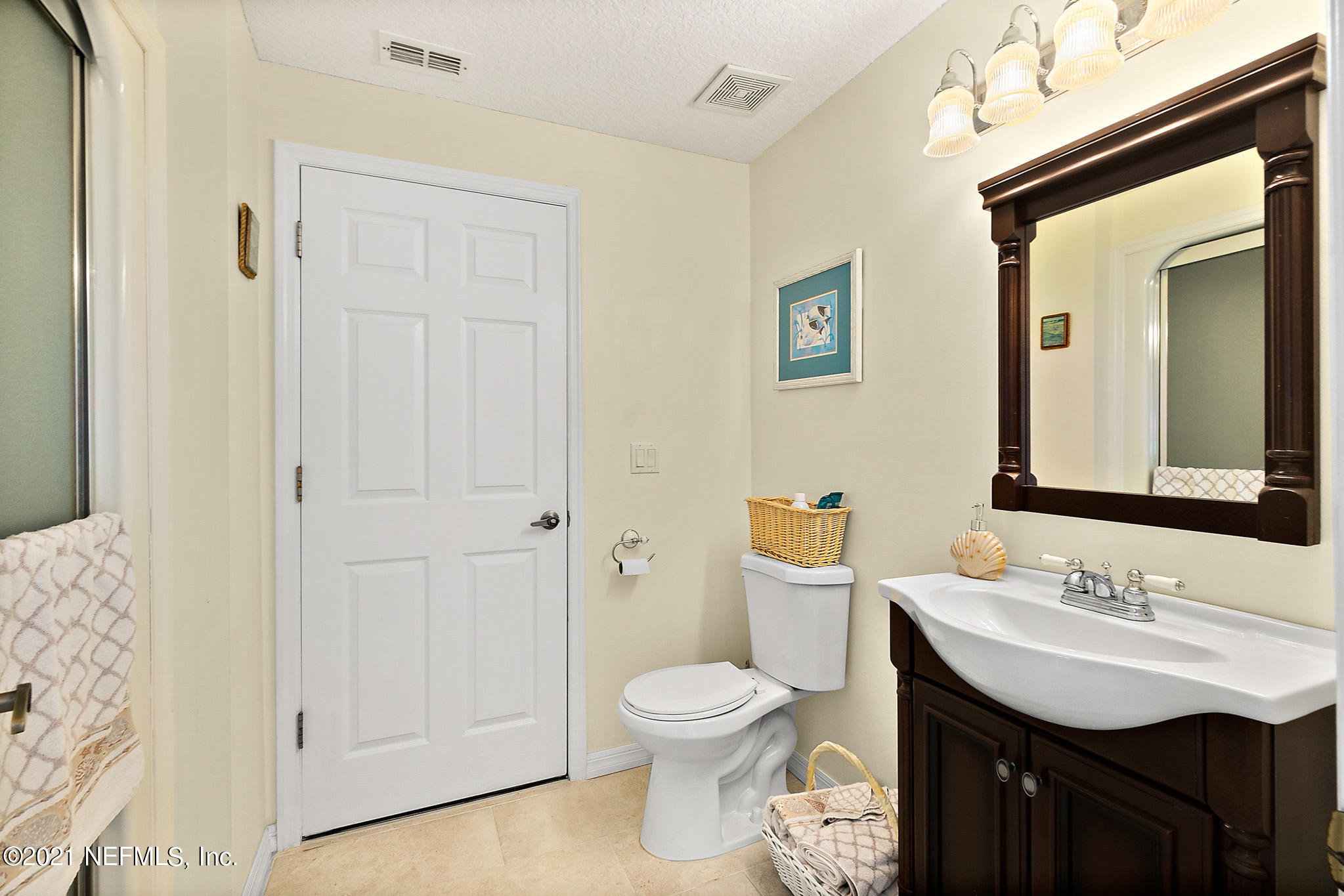9269 July Lane St. Augustine, FL 32080 - Photo 7 of 105 a bathroom with a toilet a sink and mirror