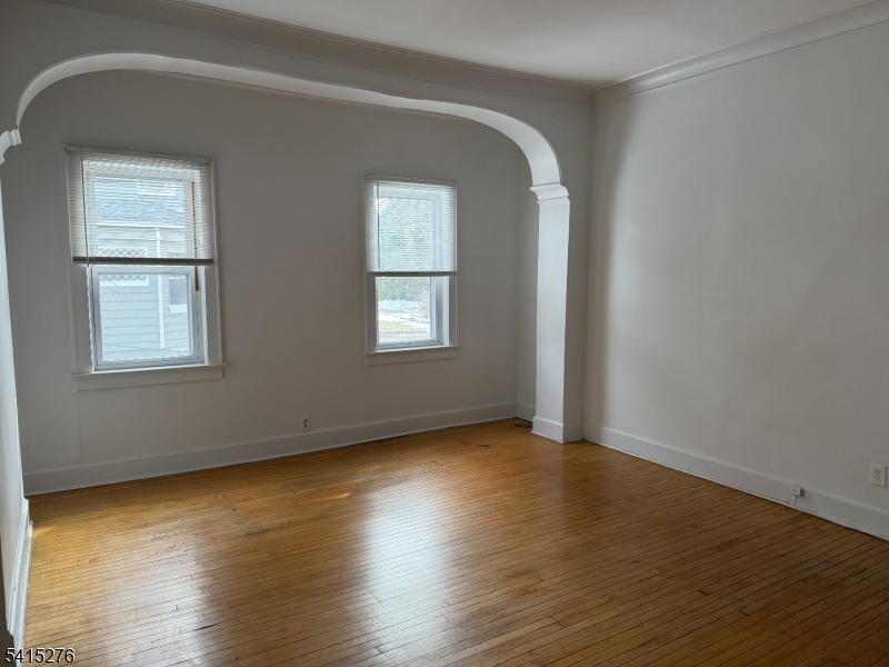 59 Walnut Street, Unit 1 Montclair, NJ 07042 - Photo 2 of 8 a view of an empty room with wooden floor and a window